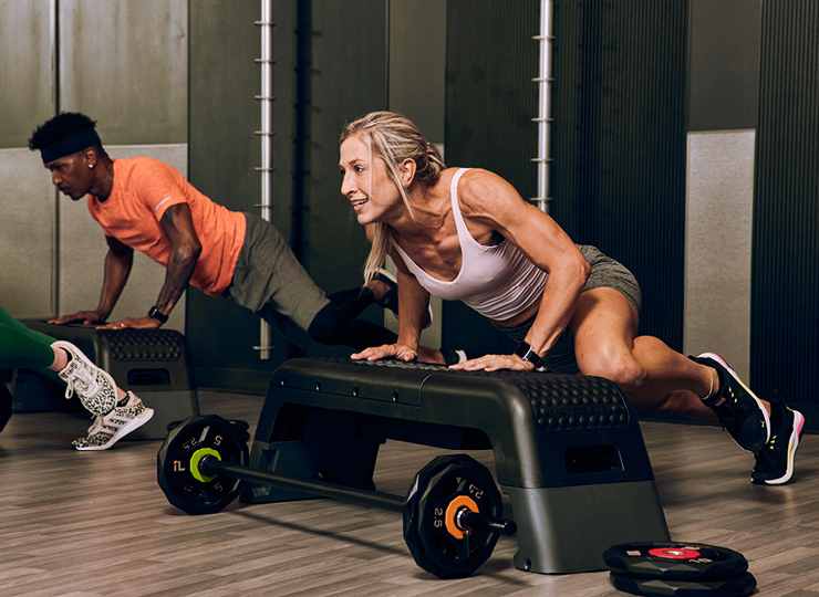 people in a b30 body class using platforms and barbells