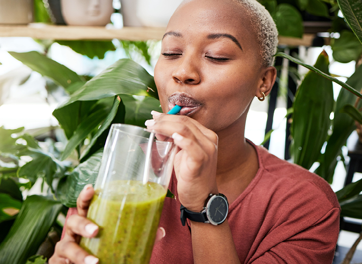 person drinking green smoothie