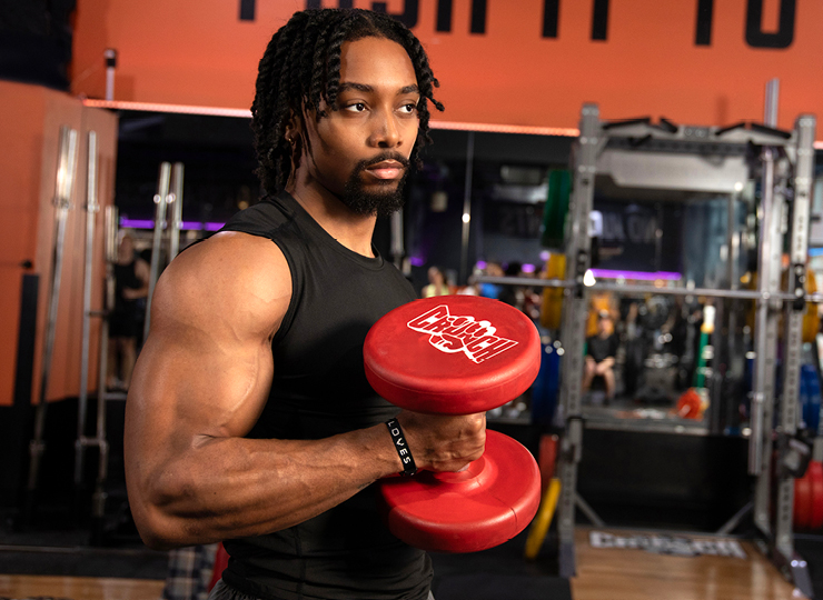 person training biceps at a crunch gym