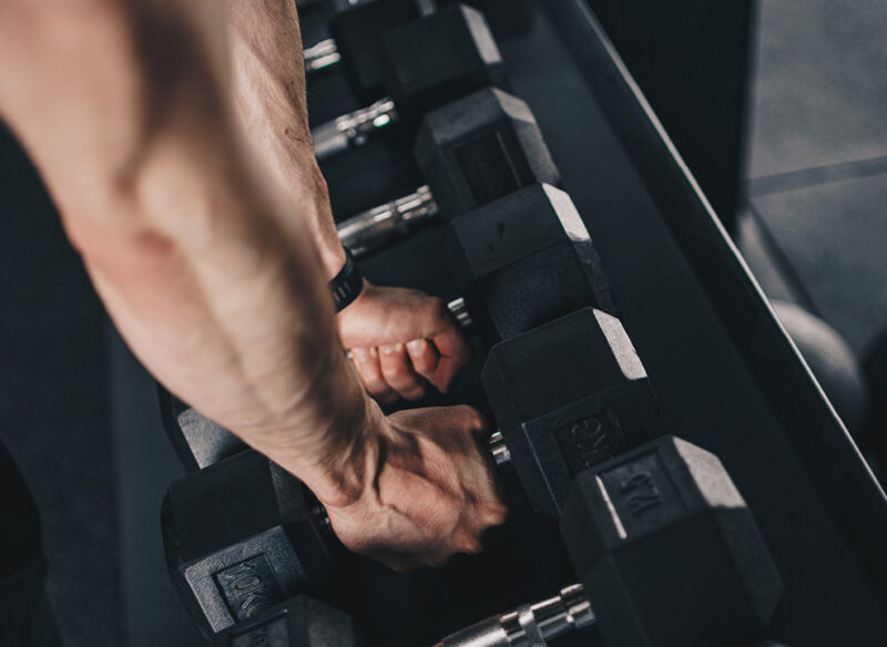 man picking up a dumbbell