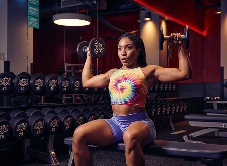 Woman doing seated dumbbell overhead press